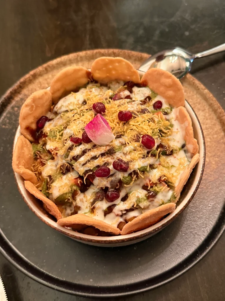 Khaar Special Chaat — crispy puri with yellow pea curry, pomegranate, and micro greens