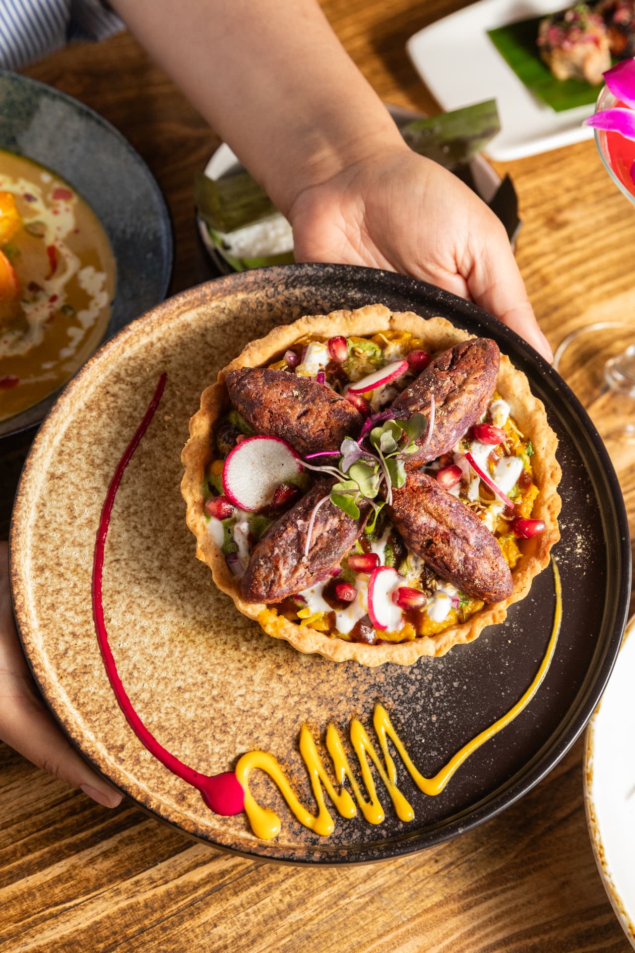 Savory tart with pomegranate and microgreens, served tableside