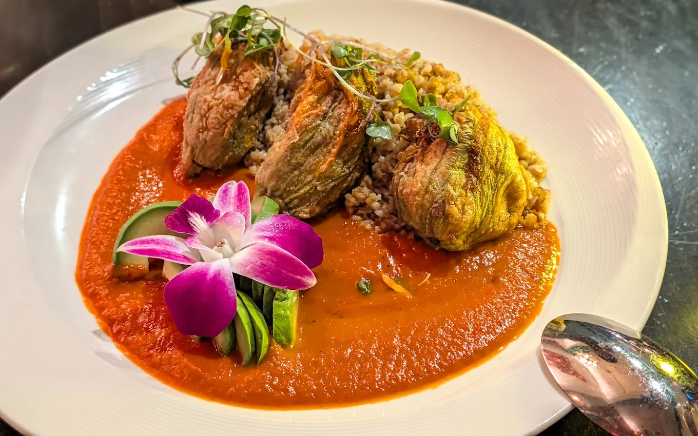 Chef's Special Golden Blossom — stuffed squash blossoms over smoked tomato sauce with an orchid