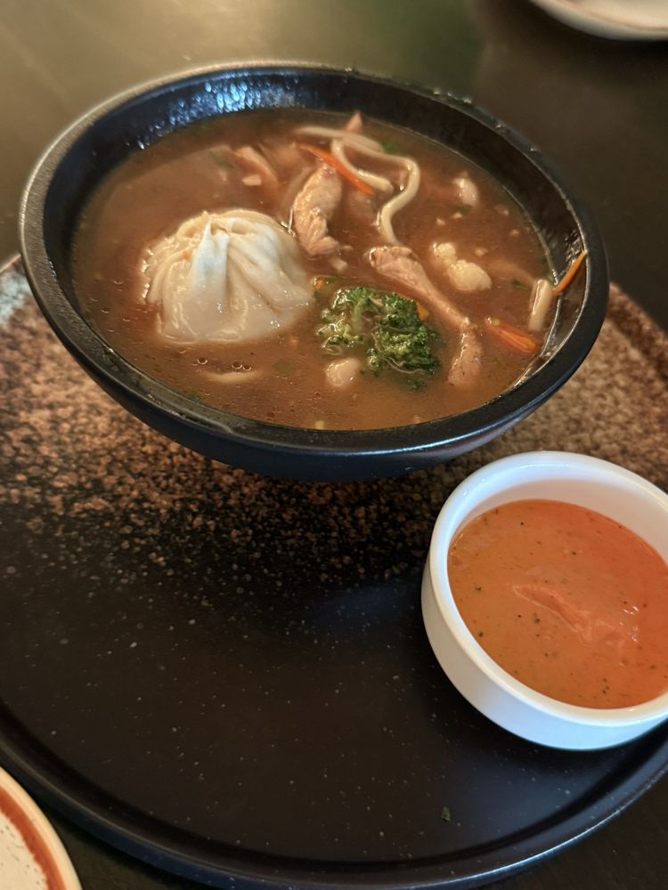 Himalayan Thukpa — noodle soup with a handcrafted momo, greens, and a side of red chutney